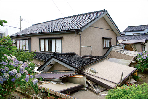 地震により倒壊した家